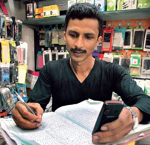Sabin, who runs a mobile recharge outlet in Kaloor, says the number of daily customers coming for recharging has gone down sharply from around 200 to 50 | K Shijith