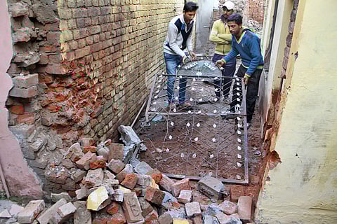 Villagers move damaged gate of their house after shelling from the Pakistani side on the India-Pakistan international border at Arnia Sector about 45km from Jammu on Saturday. | PTI