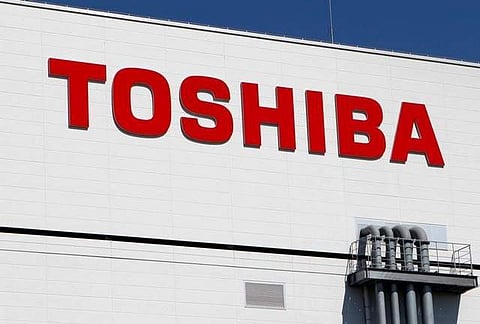 The logo of Toshiba is pictured on its flash memory factory, seen during a media tour in Yokkaichi, western Japan September 9, 2014. REUTERS