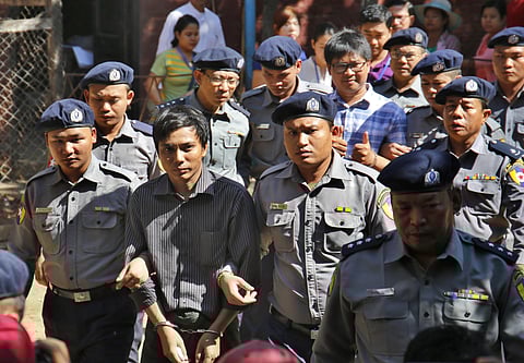 Myanmar police officers escort detained Reuters journalists Kyaw Soe Oo (second from left) and Wa Lone (fourth from left in back row) from a court after a hearing in Yangon (File | AP)