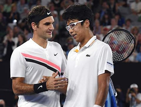 Switzerland's Roger Federer, left, is congratulated by South Korea's Hyeon Chung after Chung retired injured from their semifinal at the Australian Open tennis championships in Melbourne. | AP
