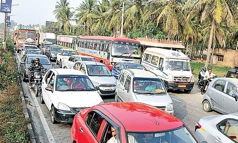 An ambulance stuck in traffic on Mysuru-Srirangapatna road on Sunday I UDAYSHANKAR S