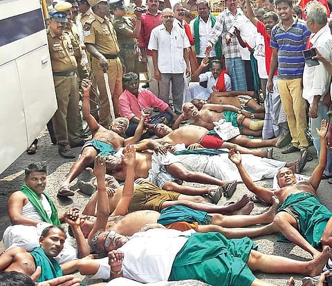 Farmers lying on a road after police restricted their entry into the railway station in Tiruchy on Sunday | EPS