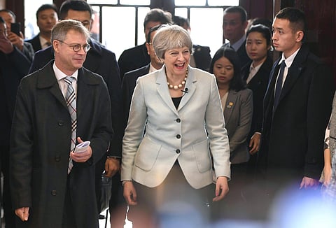 In this photo released by China's Xinhua News Agency, British Prime Minister Theresa May, center, visits Wuhan University in Wuhan in central China's Hubei Province, Wednesday, Jan. 31, 2018. (Xiao Yijiu/Xinhua via AP)