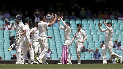 England's James Anderson, left, looks down the pitch as Australians celebrate at the end the last day of their Ashes cricket test match against England in Sydney in Monday. (Photo: AP)