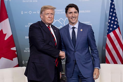 In this June 8, 2018, photo, Canada's Prime Minister Justin Trudeau meets with U.S. President Donald Trump at the G7 leaders summit in La Malbaie, Quebec. The U.S. and Canada reached the basis of a free trade deal Sunday night, a senior Canadian governmen
