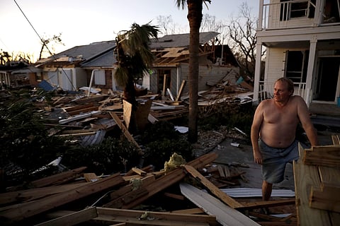 Dave Mullins looks out over the damage in front of his home, seen in background left, where he rode out hurricane Michael in Mexico Beach, Fla., Friday, Oct. 12, 2018. 'Right now I just need communication,' said Mullins of not having cell phone service. (