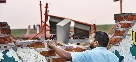 A man looks past the damaged compound wall of the Tiruchy airport, which was hit by a plane during take-off; and (right) the damaged belly of the plane in Mumbai | MK Ashok Kumar