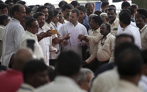 Congress president Rahul Gandhi, center, receives a memorandum from employees of the state-run aerospace and defense company Hindustan Aeronautics Ltd (HAL) outside company's corporate headquarters in Bangalore, India, Saturday, October 13, 2018. | AP