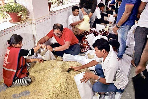 Food packets being prepared by Red Cross cadets for distribution among the affected people in flood-hit districts, in Bhubaneswar on Friday | express