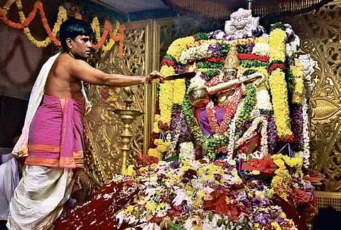 A priest offers harathi to Kanaka Durga adorned in Saraswathi alankaram