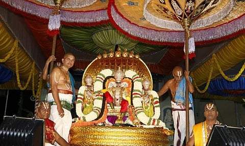 Lord Malayappa Swamy along with His two consorts being taken out on Pedda Sesha Vahanam at Tirumala.| Express