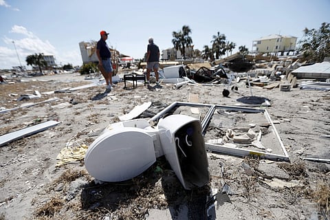 Neighbors Bob Coleman, left, and Ron Adkisson, search the sites of their former homes in the aftermath of Hurricane Michael in Mexico Beach, Fla.( Photo | AP)