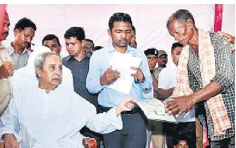 Chief Minister Naveen Patnaik distributing pattas to the victims of landslide at Baraghar village in Gajapati district on Wednesday | Express