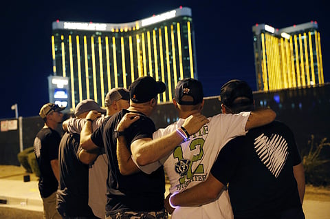 Survivors return to the scene of a mass shooting on the first anniversary, Monday, Oct. 1, 2018, in Las Vegas. Hundreds of survivors of the Las Vegas mass shooting have formed a human chain around the shuttered site of a country music festival where a gun