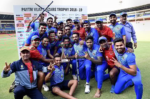 Mumbai players pose with the trophy after beating Delhi in Vijay Hazare trophy final match. (Photo | PTI)