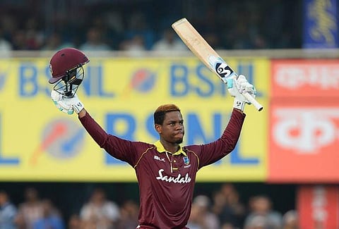 West Indies batsman Shimron Hetmyer raises his bat and helmet after he completed his century (100 runs) during the first one day international (ODI) cricket match between India and West Indies at Barsapara Cricket Stadium in Guwahati on October 21, 2018.