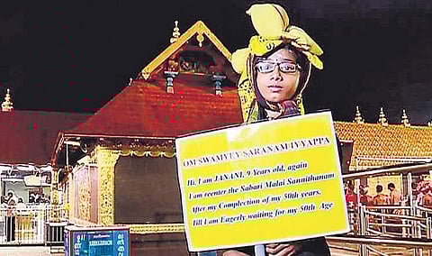 Janani holding a placard saying she will return to Sabarimala after she turns 50
