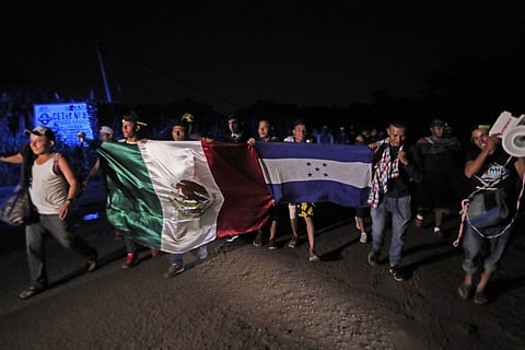 Central American migrants traveling with a caravan to the U.S. walk holding national flags from Mexico and Honduras, as they make their way to Mapastepec, Mexico, Wednesday, Oct. 24, 2018. (Photo | AP)