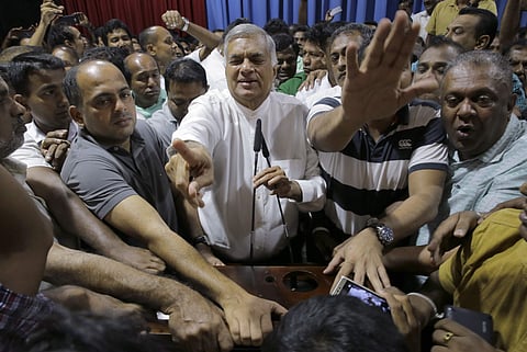 Sri Lanka's sacked Prime Minister Ranil Wickeremesinghe (C) interacts with his supporters at his official residence in Colombo | AP