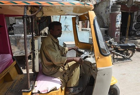In this picture taken on October 16, 2018, Pakistani auto-rickshaw driver Mohammad Rasheed drives his rickshaw in Korangi, a slum area in the eastern district of Karachi.