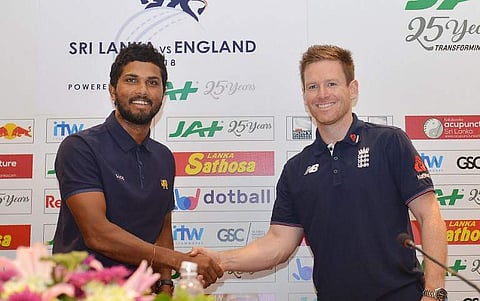Sri Lankan cricket team captain Dinesh Chandimal (L) and England cricket captain Eoin Morgan shake hands as they pose for photographers at a press conference in Colombo. (Photo | AFP)