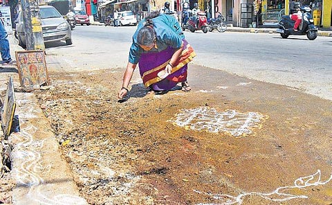 A BBMP pourakarmika drawing rangoli to rid Bengaluru of garbage blackspots. The high court has given the BBMP time till October 31 to clean the city | SHRIRAM B N