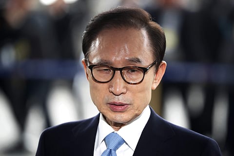 In this March 14, 2018, file photo, former South Korean President Lee Myung-bak arrives for questioning over bribery allegations at the Seoul Central District Prosecutors' Office in Seoul, South Korea. A South Korean court has sentenced former President L