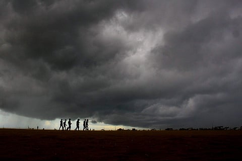 People walk at Marina Beach as dark clouds gather in the sky in Chennai on Friday. (Photo: EPS / Debadatta Mallick)