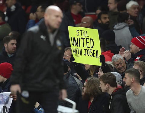 Supporters of Manchester United's manager Jose Mourinho hold up a placard after the end of the English Premier League match between Manchester United and Newcastle United at Old Trafford | AP