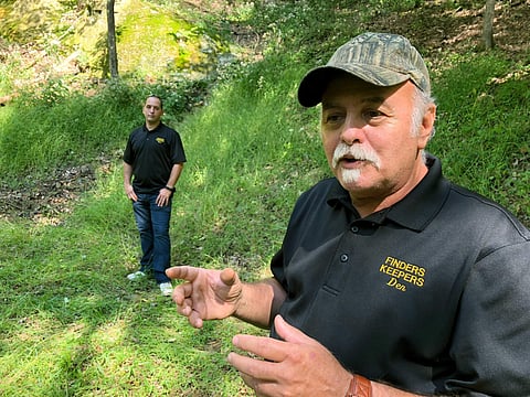 In this Sept. 20, 2018 photo, Dennis Parada, right, and his son Kem Parada stand at the site of the FBI’s dig for Civil War-era gold in Dents Run, Pennsylvania. (Photo | AP)