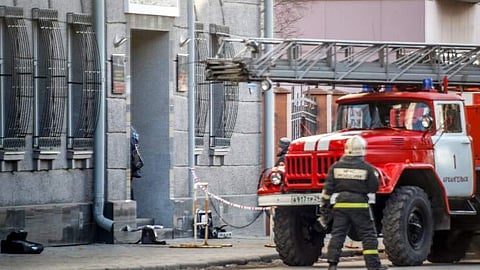 A Russian firefighter walks near a fire-engine at building housing the FSB security service in Arkhangelsk | AFP