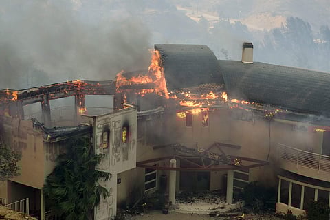 The Woolsey Fire burns a home near Malibu Lake in Malibu, California, Nov. 9, 2018. (Photo | AP)
