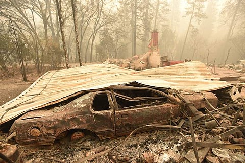 A burned vehicle is seen at the remains of a residence after the Camp fire tore through the area in Paradise, California, on November 10, 2018. (Photo | AFP)