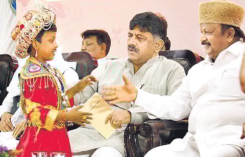 A boy dressed as Tipu Sultan greets minister D K Shivakumar and MLA Roshan Baig at Vidhana Soudha on Saturday | SHRIRAM B N