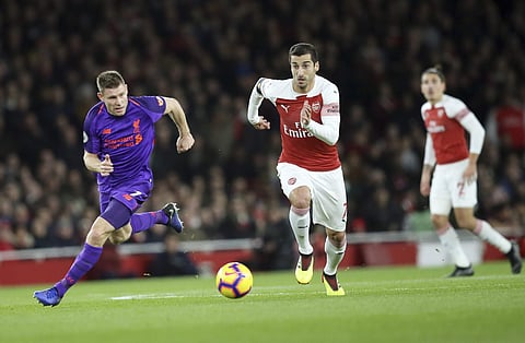 Arsenal's Henrikh Mkhitaryan runs with the ball followed by Liverpool's James Milner, left, during the English Premier League soccer match between Arsenal and Liverpool at Emirates stadium in London. (Photo | AP)