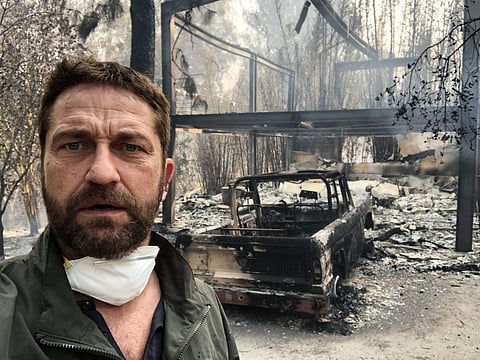 Gerard Butler tweeted with a photo of himself standing against his destroyed house in Malibu. (Photo | Twitter @gerardbutler)