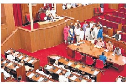Opposition members stand in the well of the Assembly on Saturday | Express