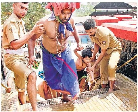 The police assist a devotee at the holy steps | Shaji Vettipuram