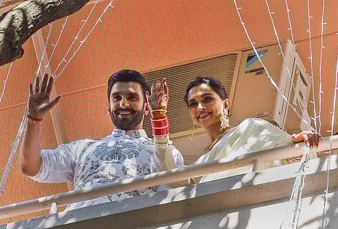 Newly-married Bollywood actors Ranveer Singh and Deepika Padukone greet their fans from the balcony of their residence in Bengaluru Tuesday. (Photo | PTI)