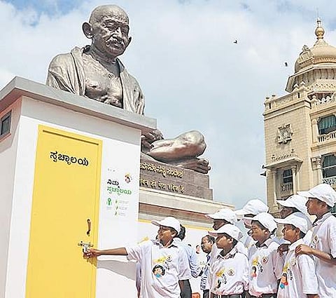 Students look at a model toilet during a World Toilet Day programme held at Vidhana Soudha on Monday | Pushkar V