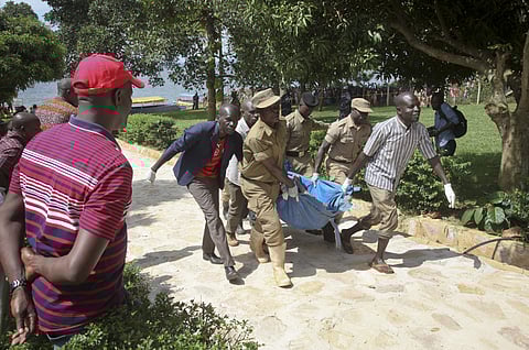 Ugandan police carry away a body of one of the victims of a boat which capsized in Lake Victoria near the capital, Kampala, Uganda. ( Photo | AP)