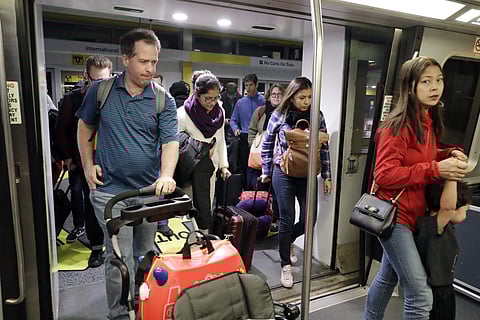 Travelers get on a airport train at O'Hare International Airport in Chicago. (Photo | AP)