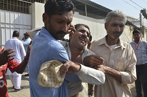 People comfort a family member of a police officer killed during a shootout at the Chinese Consulate in Karachi, Pakistan.( Photo | AP)