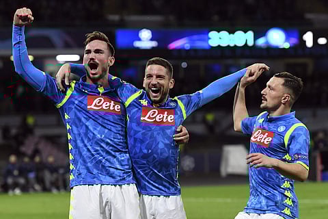 Napoli's Dries Mertens (C) celebrates with teammates Fabian Ruiz (L) and Mario Rui after scoring during the Champions League Group C match against Red Star Belgrade at the San Paolo stadium | AP