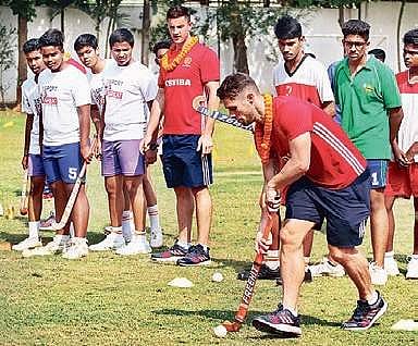 Players of England team show hockey tricks to students of SAI International School in Bhubaneswar on Wednesday I Express