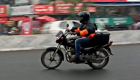 A Swiggy delivery man on his bike on the way to deliver food. (Photo | EPS)