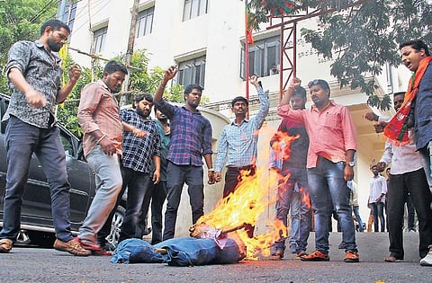 Supporters of State BJP spokesperson Koradala Naresh burn Yoganand in effigy at BJP State office, in Hyderabad on Friday; (right) Dhanpal Suryanarayana Gupta’s followers damage chairs in Nizamabad party office |S Senbagapandiyan