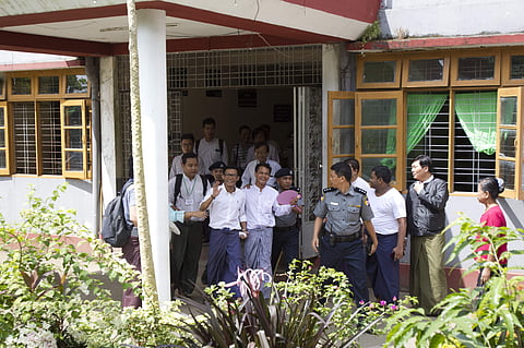 Myanmar journalists from Eleven Media Group Kyaw Zaw Lin, center left, Phyo Wai Win, center right, leave a township court Wednesday, Oct. 17, 2018, in Yangon, Myanmar.