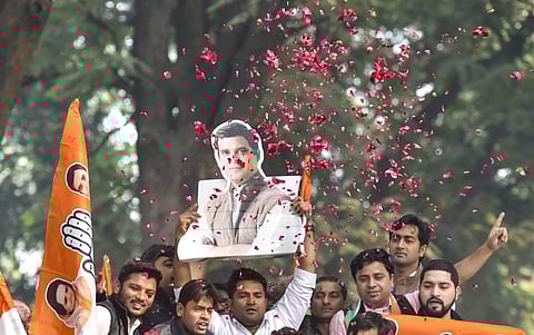 Congress Party workers display Congress President Rahul Gandhi's cutout as they celebrate after initial trends showed the party leading in the state Assembly election results at the Congress headquarters in New Delhi. (Photo | PTI)